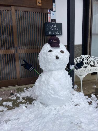 a snowman is standing in front of a sign at Guest House Hinode in Takayama