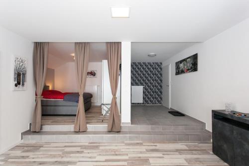 a bedroom with a bed and curtains in a room at Kaiser - Ferienwohnungen Dreiburgenblick in Patersberg
