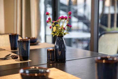 a blue vase with flowers sitting on a table at Lalita Boutique Hotel & Spa Ninh Binh in Ninh Binh