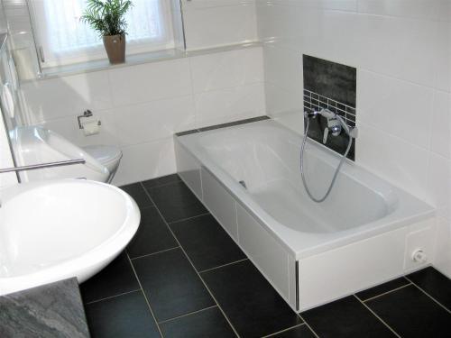 a white bathroom with a tub and a toilet at Ferienwohnung Becker in Büren