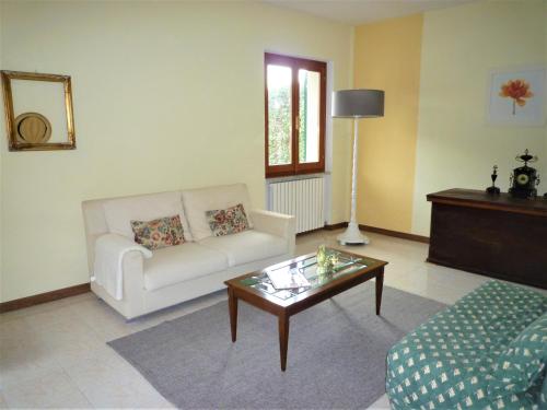 een woonkamer met een witte bank en een salontafel bij Casa Benera in Maissana