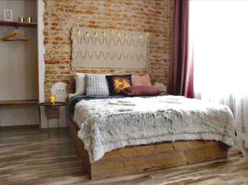 a bedroom with a bed with a brick wall at Dorosh-HOME квартира-студія в центрі Львова in Lviv