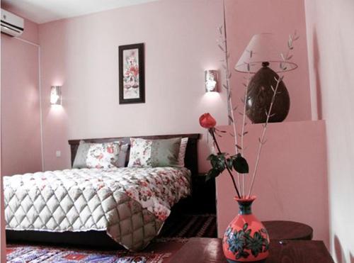 Un dormitorio con una cama y un jarrón con flores. en Kasba Oum Hani d'Ouzoud en Ouzoud