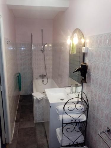 une salle de bain blanche avec un lavabo et une douche dans l'établissement Hôtel Confort 09 ou HC-09, à Tarascon-sur-Ariège