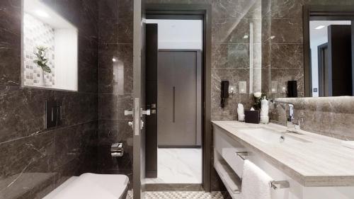 a bathroom with a toilet and a sink at SUHA Mina Rashid Hotel Apartments in Dubai