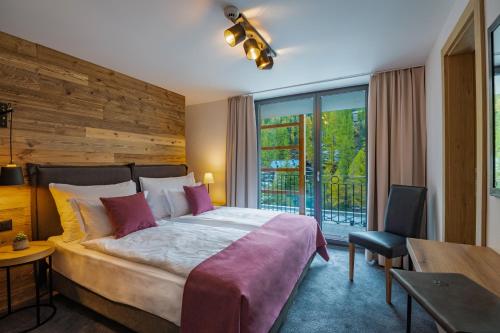a bedroom with a large bed and a balcony at 22 Summits Apartments in Zermatt