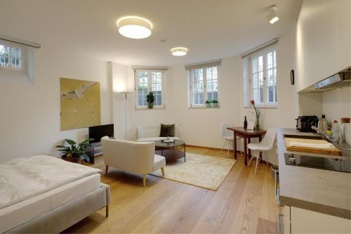 a living room with a bed and a kitchen at Boutique Apartments Freiburg - Elisabeth in Freiburg im Breisgau