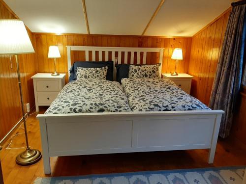 a bedroom with a white bed with two lamps at Chalet Am Fels in Innertkirchen