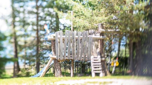 a wooden play structure with a ladder on a playground at Residence Lärchenhäusl in Soprabolzano