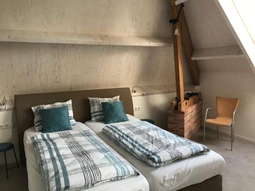 a bedroom with two beds in a attic at Hendrikhof Appartement 3 ‘het Gebint’ in Westkapelle