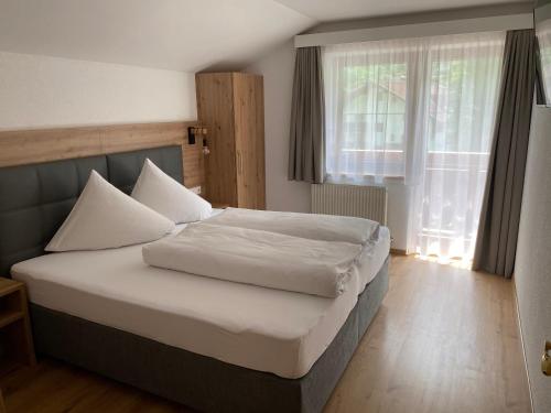 1 dormitorio con 1 cama con sábanas blancas y ventana en Apart Soliva, en See