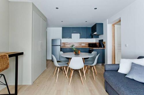 un salon avec une table, des chaises et un canapé dans l'établissement Appartement nature, à Thônes