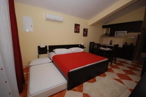 1 dormitorio con 1 cama con manta roja en Apartments Stepic, en Trogir
