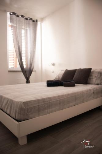 Ce lit se trouve dans un dortoir blanc doté d'une fenêtre. dans l'établissement Affittacamere dei Mercanti, à Sassari
