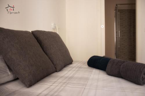 - un lit avec 3 oreillers bruns au-dessus dans l'établissement Affittacamere dei Mercanti, à Sassari