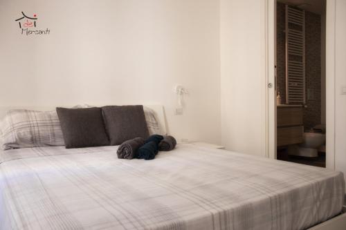 un lit blanc avec un animal rembourré au dessus dans l'établissement Affittacamere dei Mercanti, à Sassari
