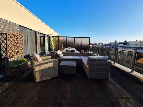 a balcony with chairs and a table on a roof at Le penthouse de Kelly in Koksijde