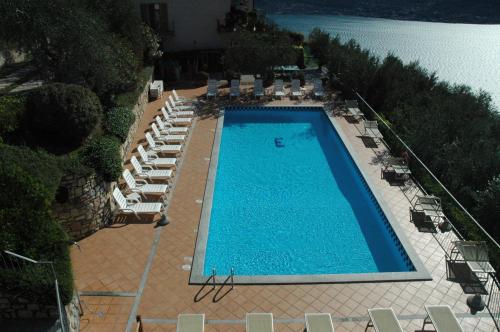 an overhead view of a large swimming pool with chairs and water at Residence Erika in Tignale