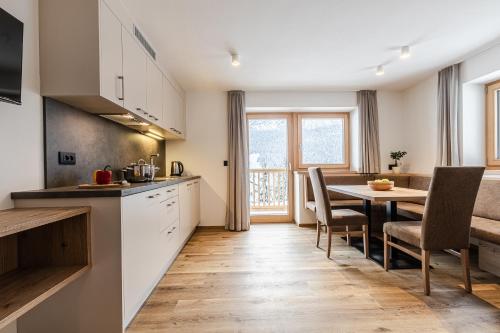a kitchen and dining room with a table and chairs at Niciora in Badia