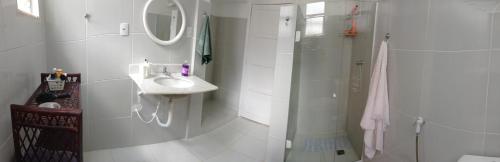 y baño blanco con lavabo y ducha. en Apartamento Aluguel, en Salvador