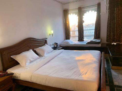 a bedroom with two beds and a window at Hotel The Tiger in Udaipur