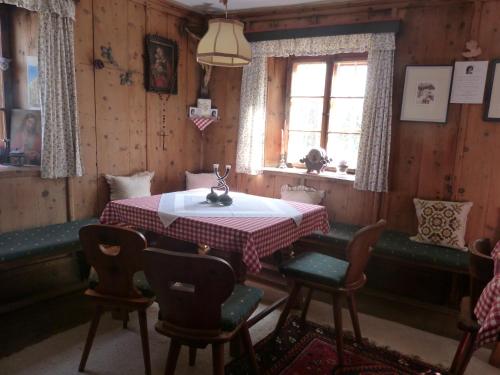 una sala da pranzo con tavolo, sedie e finestra di Haus Driendl a Mieders