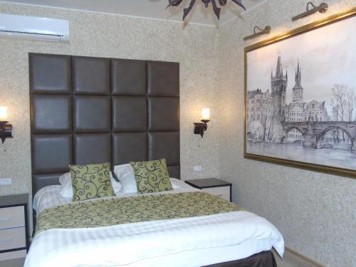 1 dormitorio con 1 cama grande y una foto en la pared en Domashny Ochag, en Ujtá