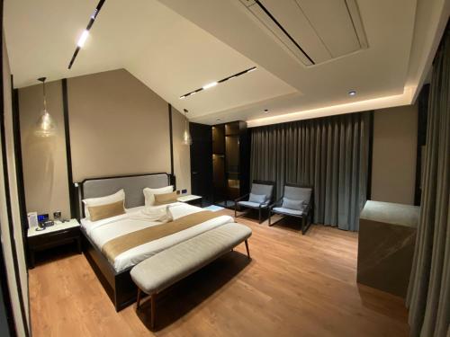 a bedroom with a large bed and two chairs at Radhe Upavan Resort in Ahmedabad