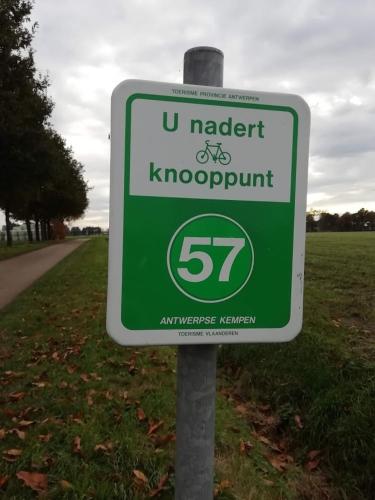 a green and white sign on the side of a road at The Mill 2380 in Ravels