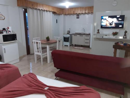 a living room and kitchen with a couch and a table at loft harmonia in Blumenau