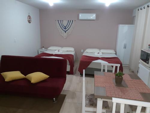 a living room with two beds and a couch at loft harmonia in Blumenau