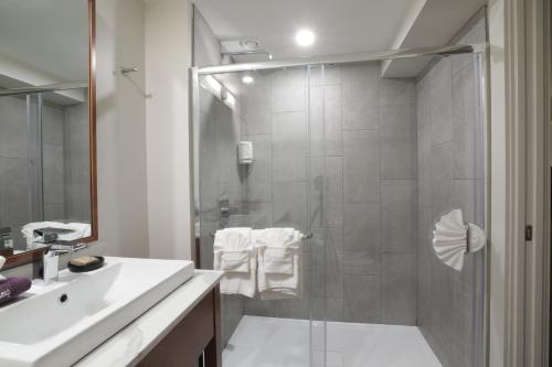 a bathroom with a shower and a white sink at Lake Placid Inn Boutique Hotel in Lake Placid