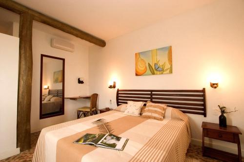 a bedroom with a large bed with two magazines on it at Pipa Ecovila Master in Pipa