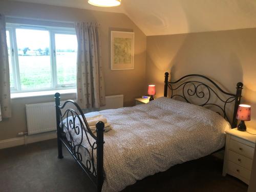 a bedroom with a large bed and a window at The Garden Loft in Freethorpe