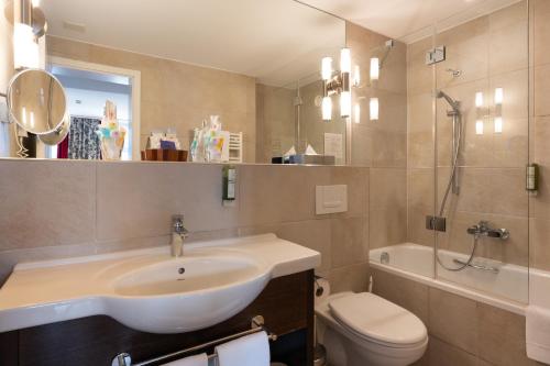 a bathroom with a sink and a toilet at Hotel Krebs Interlaken in Interlaken