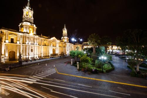 a large building with a clock tower at night at La Plaza Arequipa Hotel Boutique in Arequipa