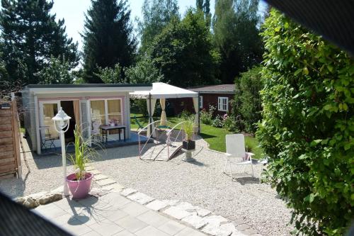 a garden with a shed with a table and chairs at Ferienwohnung Elfenbrücke in Lehrberg