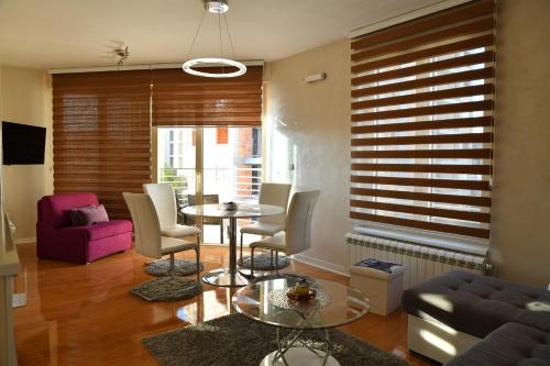 a living room with a table and chairs at Apartman STUPOVI Zlatibor in Zlatibor