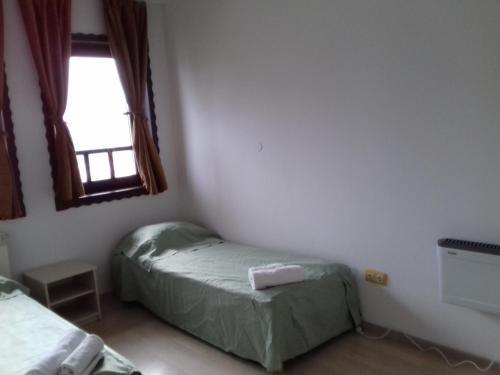 a small room with two beds and a window at Green Oaza Apartment in Fojnica