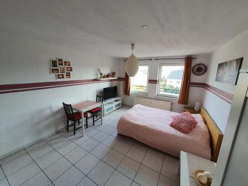 a bedroom with a bed and a desk and a table at Studio Filo in Liège