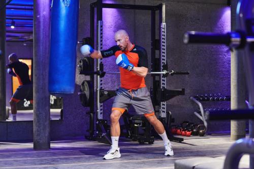a man in a gym with a boxing glove at SCHLOSS Zermatt - CBD & Adaptogenic Spa and Sport Hotel in Zermatt
