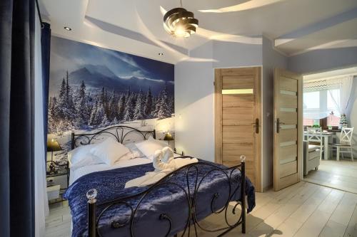 Apartamenty u Romana في تيلسز: غرفة نوم مع سرير أزرق مع لوحة جدارية لمسرح الشتاء