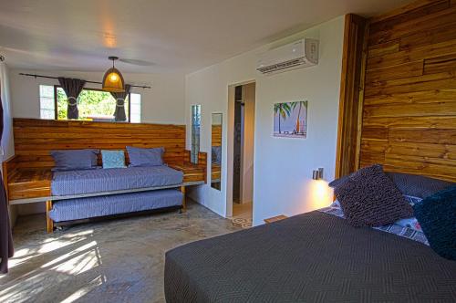 a bedroom with a bed and a couch and a window at Casa Swell Coronado A unique blend of luxury and nature in the hearth of Coronado in Playa Coronado