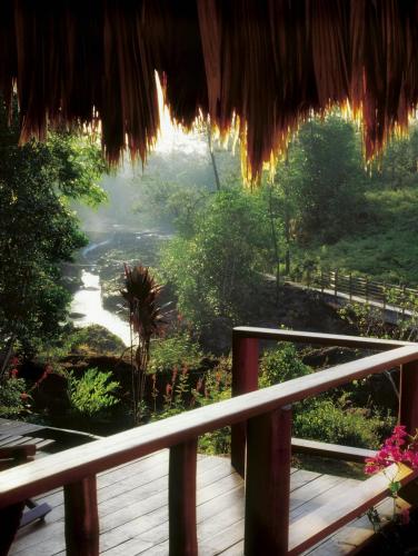 a balcony with a view of a river and trees at Blancaneaux Lodge by Francis Ford Coppola in San Ignacio