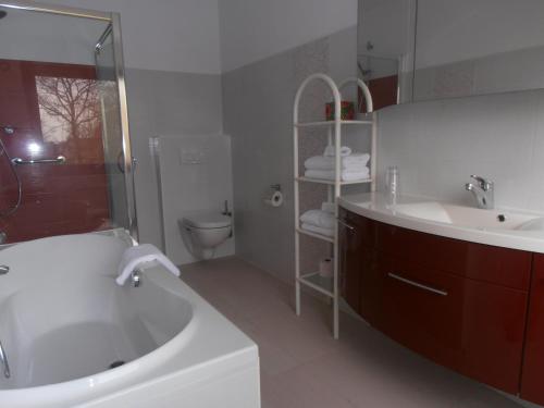 La salle de bains est pourvue d'une baignoire, d'un lavabo et de toilettes. dans l'établissement B&B Jossefin Tuinen, à Lanaken