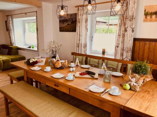 - une table en bois dans un salon avec des chaises et une salle à manger dans l'établissement Ferienhaus Bergvagabund, à Schönau am Königssee