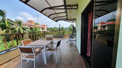 a patio with a table and chairs on a balcony at Nessies Nagaon in Alibaug