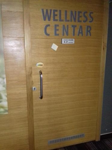 a wooden door with the wellness center written on it at Green Oaza Apartment in Fojnica