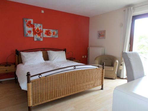 a bedroom with a bed and a red wall at B&B Jossefin Tuinen in Lanaken