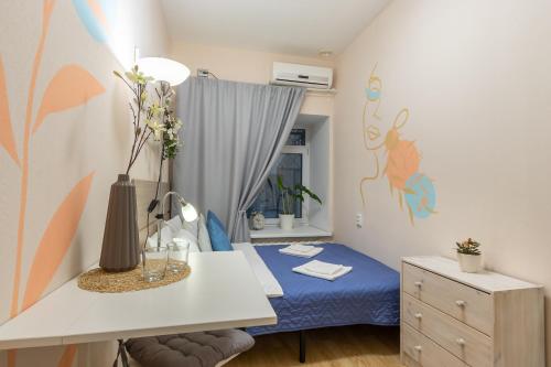 Schlafzimmer mit einem Bett, einem Schreibtisch und einem Fenster in der Unterkunft Boho Botanica Hotel on Nevskiy in Sankt Petersburg
